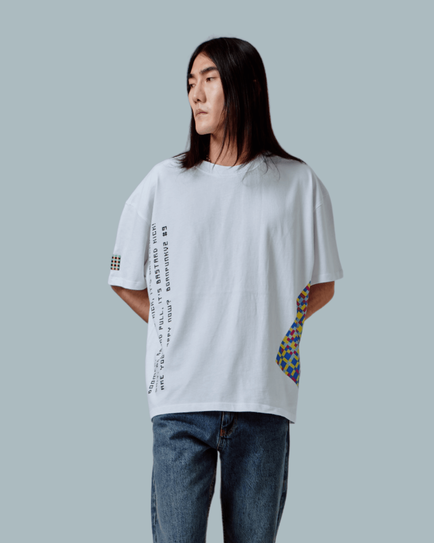 A male model wearing a green oversized T-shirt with text and glitch textures printed on front side.