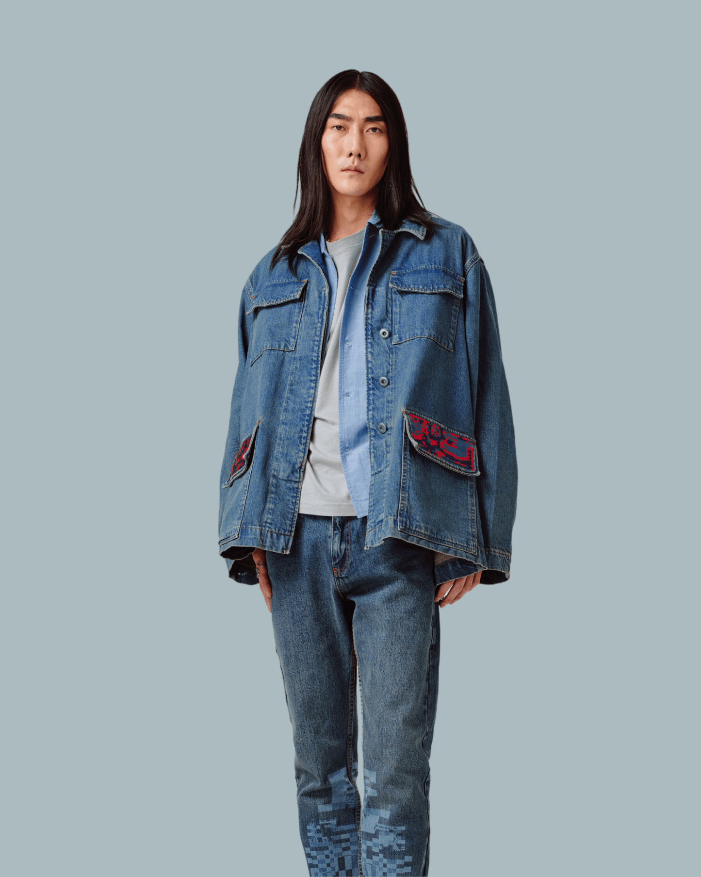 A male model wearing an oversized denim jacket, glitch textures printed on front side.