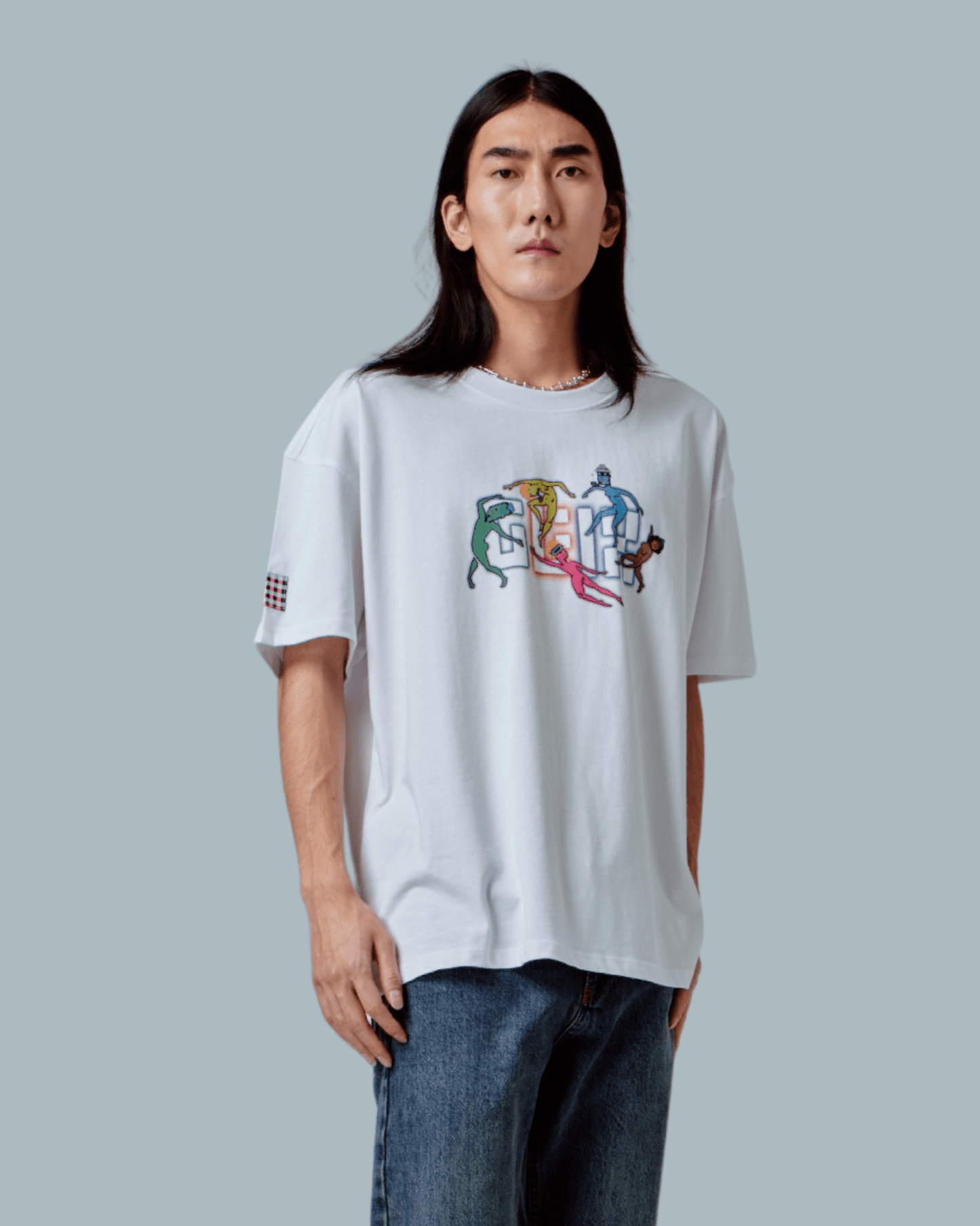A male model wearing a white oversized T-shirt with GLIX logo with dancing NFT characters embroidered, glitch textures printed on front side.