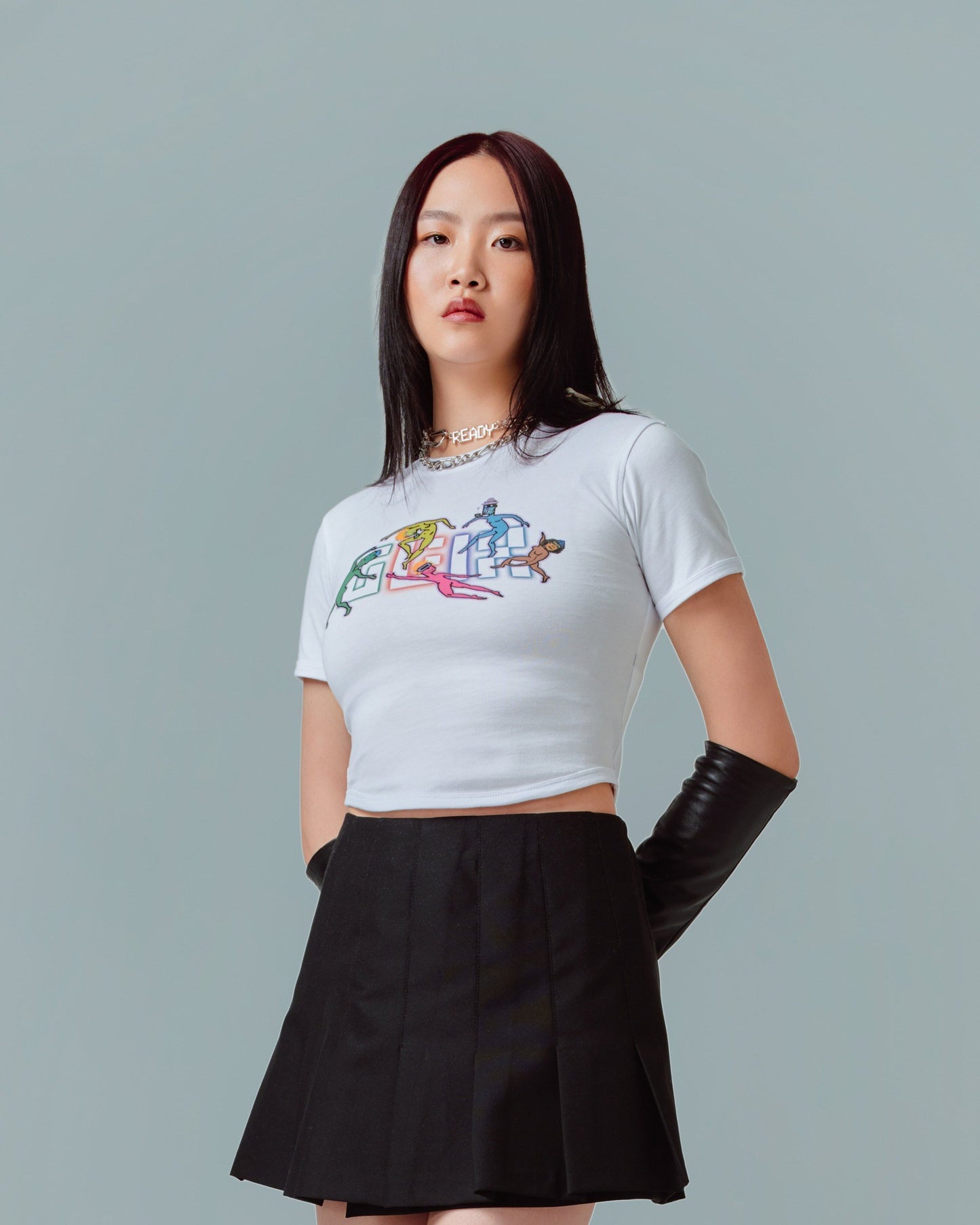 A female model wearing white crop top baby tee with glitch textures and GLIX logo printed on the front side
