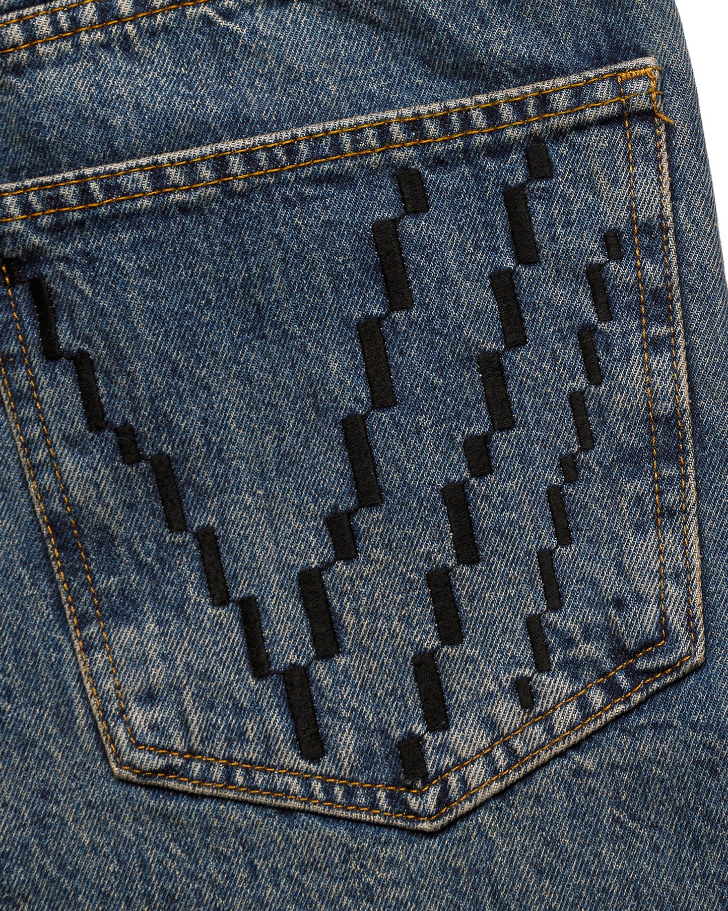 Pixelated design on a denim pocket with black lines.
