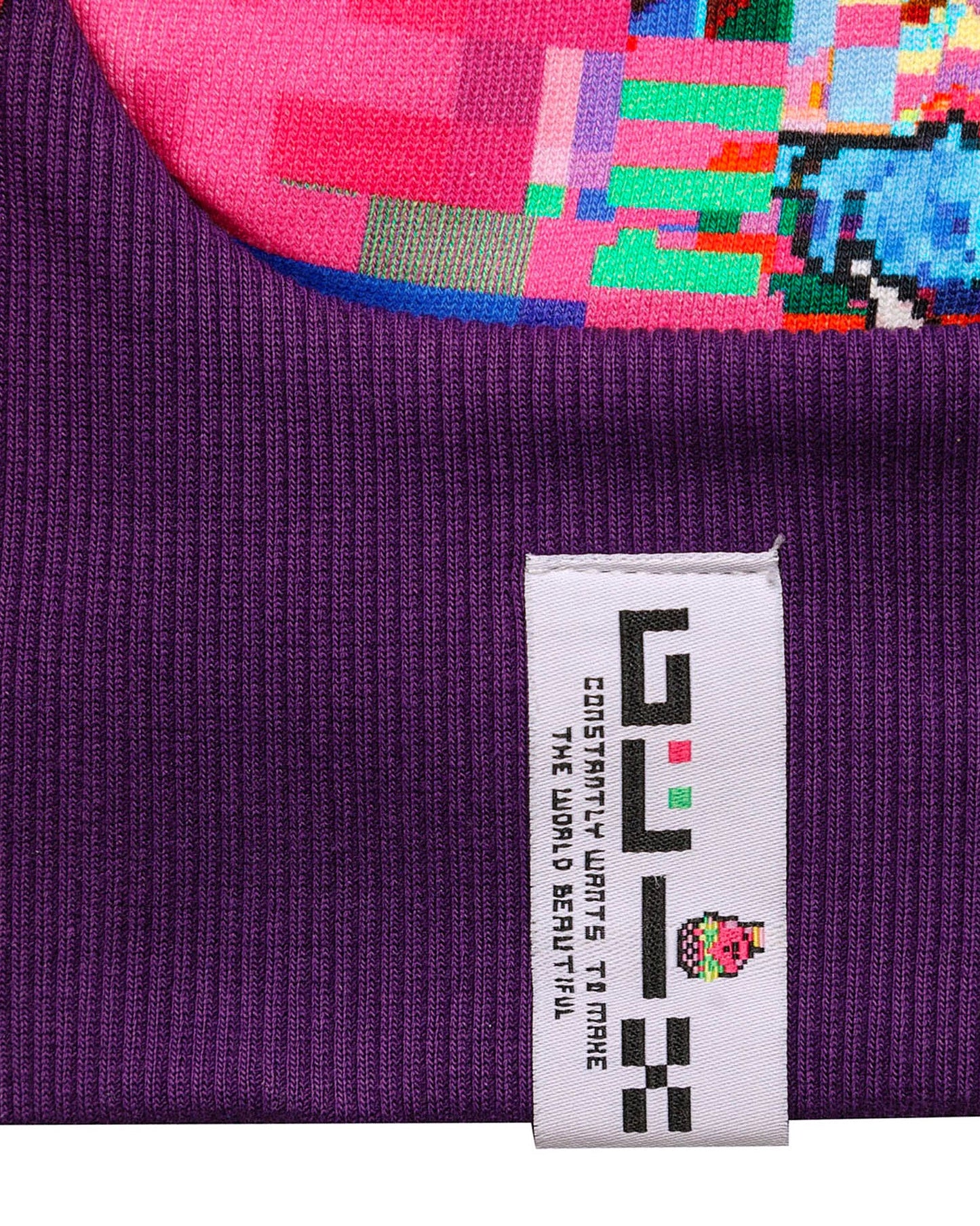 Close-up of a purple fabric with a colorful pixel art design and a visible brand label.