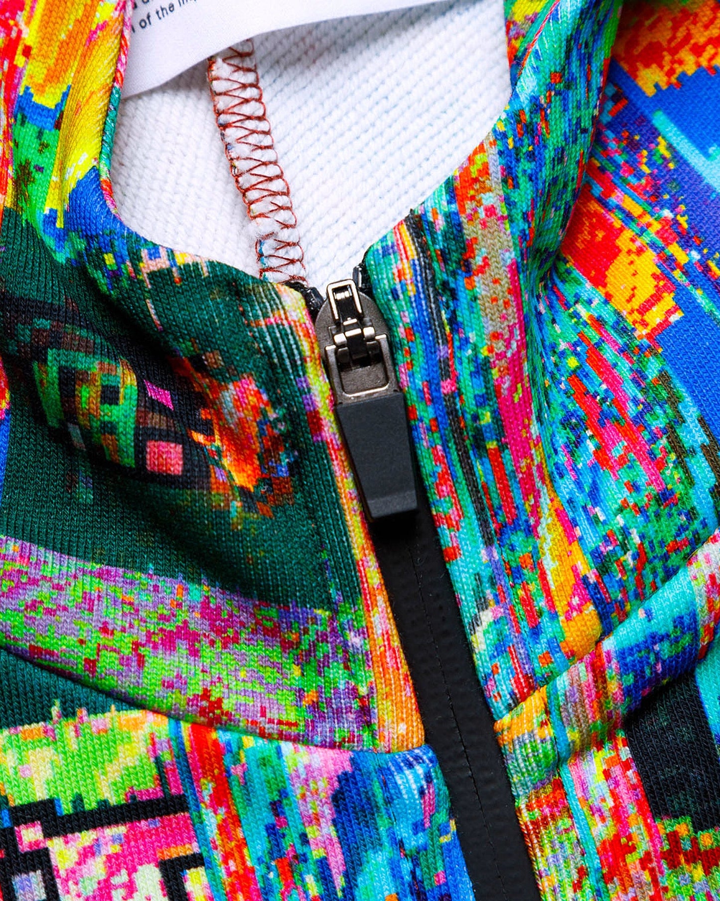Close-up of a colorful jacket with a zipper, featuring a vibrant pattern.
