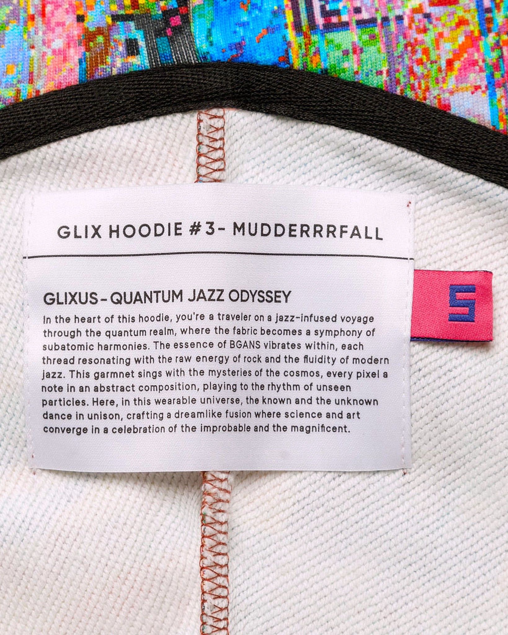 Close-up of a hoodie label with text and a brand logo on a colorful background