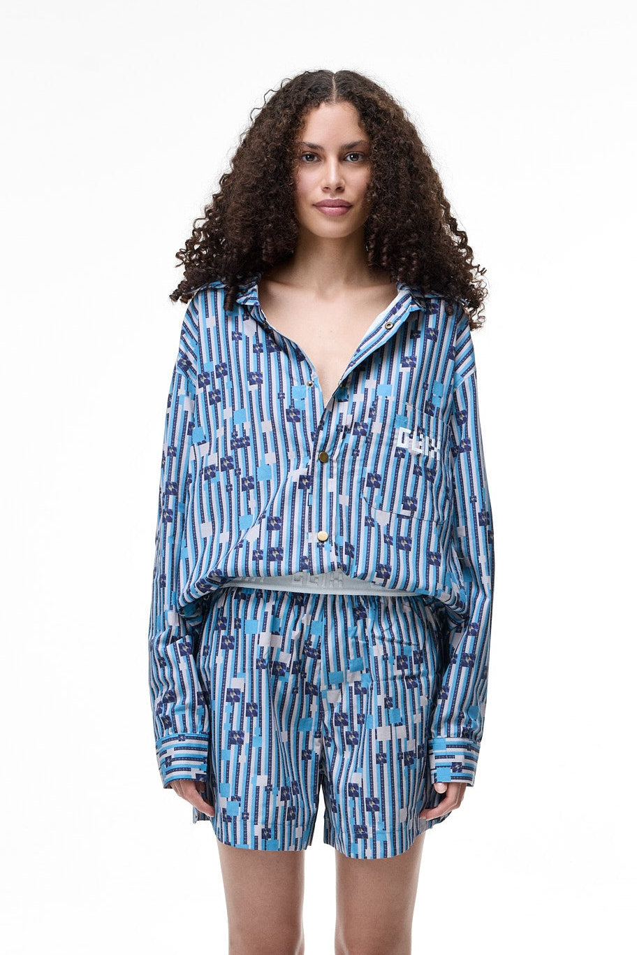 Woman wearing a blue patterned pajama set on a white background
