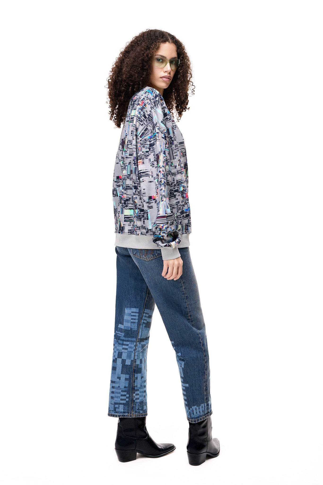 Back view of a model wearing the GLIX COLORS' ECHO sweatshirt, featuring a grey base with a vibrant, multi-colored generative glitch art pattern and architectural fit.