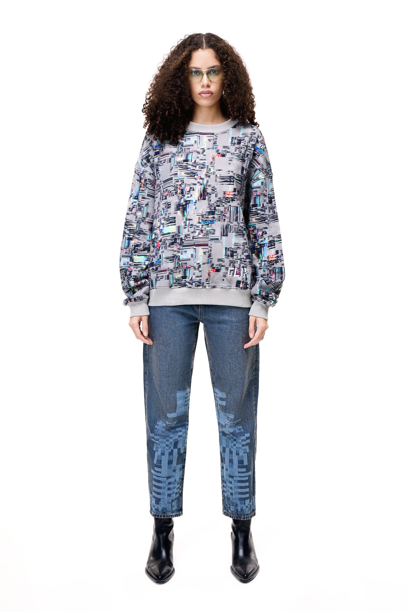 Front view of a model wearing the GLIX COLORS' ECHO sweatshirt, featuring a grey base with a vibrant, multi-colored generative glitch art pattern and architectural fit.
