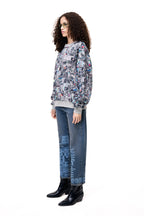 Front view of a model wearing the GLIX COLORS' ECHO sweatshirt, featuring a grey base with a vibrant, multi-colored generative glitch art pattern and architectural fit.