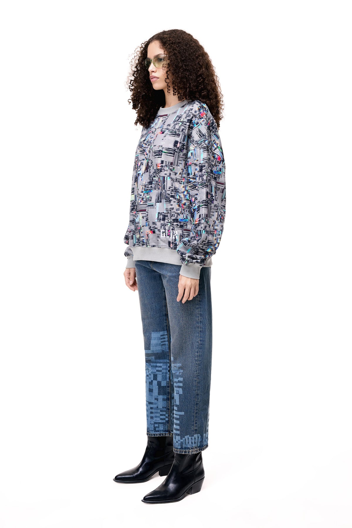 Front view of a model wearing the GLIX COLORS' ECHO sweatshirt, featuring a grey base with a vibrant, multi-colored generative glitch art pattern and architectural fit.