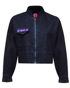 Front flat lay view of the GLIX "Totem" dark wash denim crop bomber jacket, featuring a zip-up front with blue tape detail, a single chest pocket with a purple and blue glitch logo, and a pink internal "S" size tag.