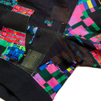 Detailed view of the GLIX "Screen Error" hoodie showing the side seam and sleeve attachment, featuring an all-over digital glitch print with vibrant pink, green, and blue pixel blocks against a dark textured background.