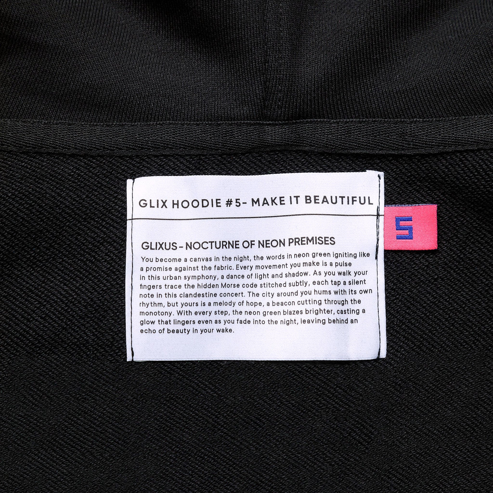 Close-up of the interior neck label for GLIX HOODIE #5 - MAKE IT BEAUTIFUL, featuring the "GLIXUS - NOCTURNE OF NEON PREMISES" brand manifesto