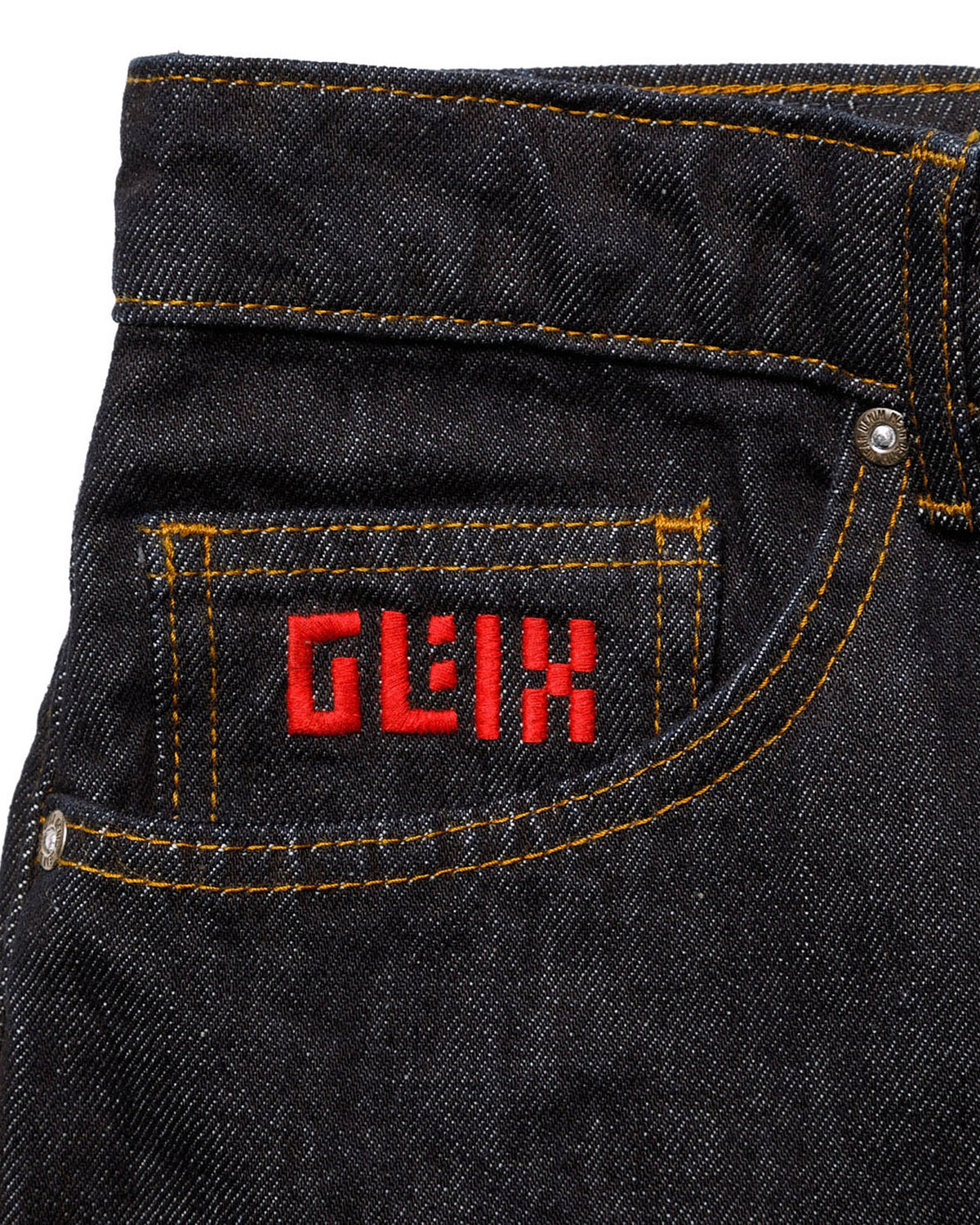 Macro close-up of the front coin pocket on the GLIX "Cumulus" feminine fit jeans, featuring a red embroidered GLIX logo on dark wash denim with contrast orange stitching.