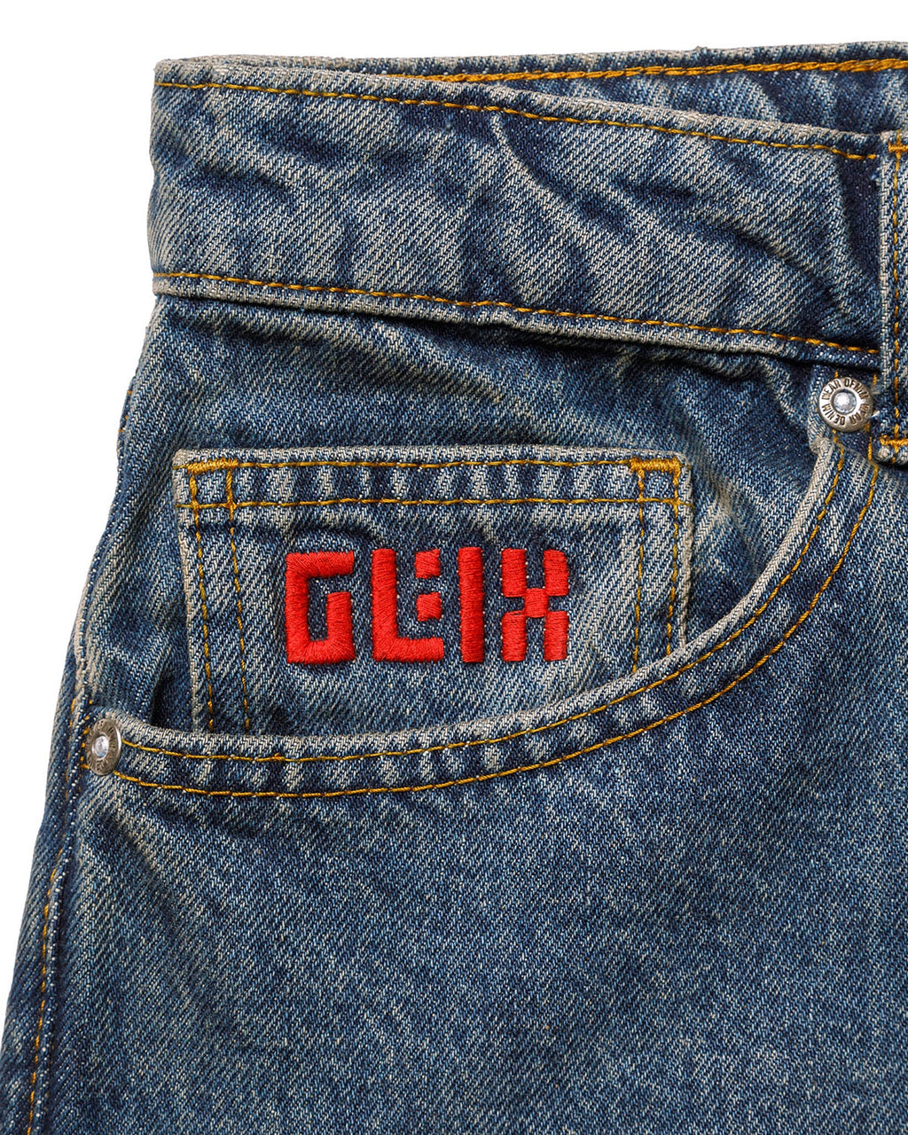 Macro close-up of the front coin pocket on the GLIX "Jetpack" feminine fit jeans, featuring a red embroidered GLIX logo on mid-wash denim with contrast orange stitching.