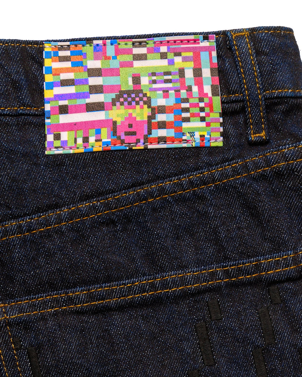 Side profile lifestyle view of a male model wearing the GLIX "The Maze" masculine fit jeans, highlighting the straight-leg silhouette and the tonal blue pixelated maze graphic printed on the lower leg of the dark wash denim.