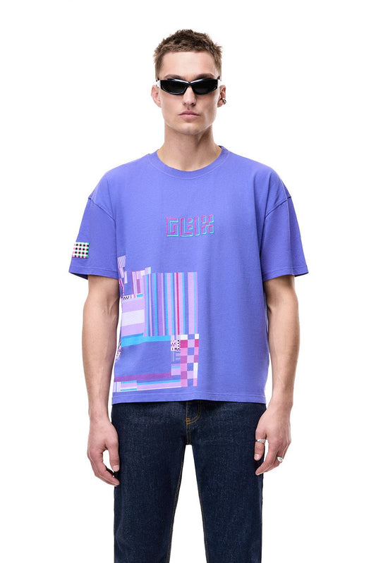 Front view of a male model wearing the purple GLIX oversized t-shirt, featuring a pink and blue 3D embroidered logo and a large geometric hem graphic, styled with black futuristic sunglasses and dark blue jeans.