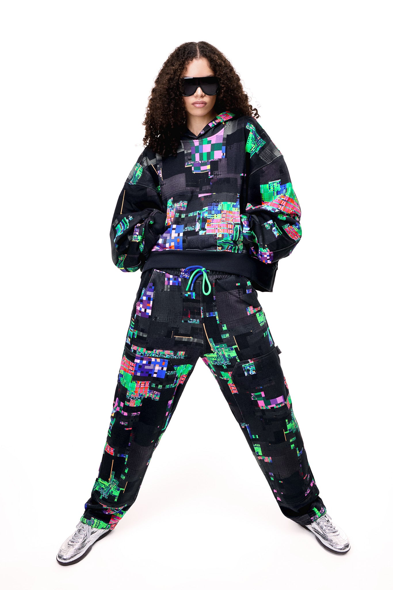 Front view of a model wearing the GLIX SCREEN ERROR black hoodie, featuring a vibrant neon generative glitch art pattern and an oversized streetwear fit.