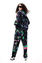 Back view of the GLIX SCREEN ERROR black hoodie and matching sweatpants, highlighting the expansive digital distortion print and architectural silhouette.