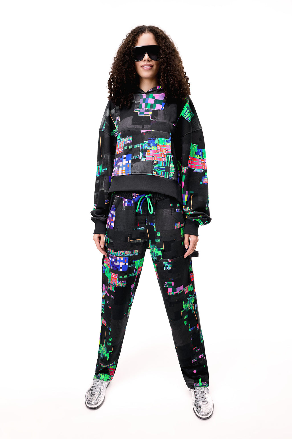 Front view of a model wearing the GLIX SCREEN ERROR black hoodie, featuring a vibrant neon generative glitch art pattern and an oversized streetwear fit.