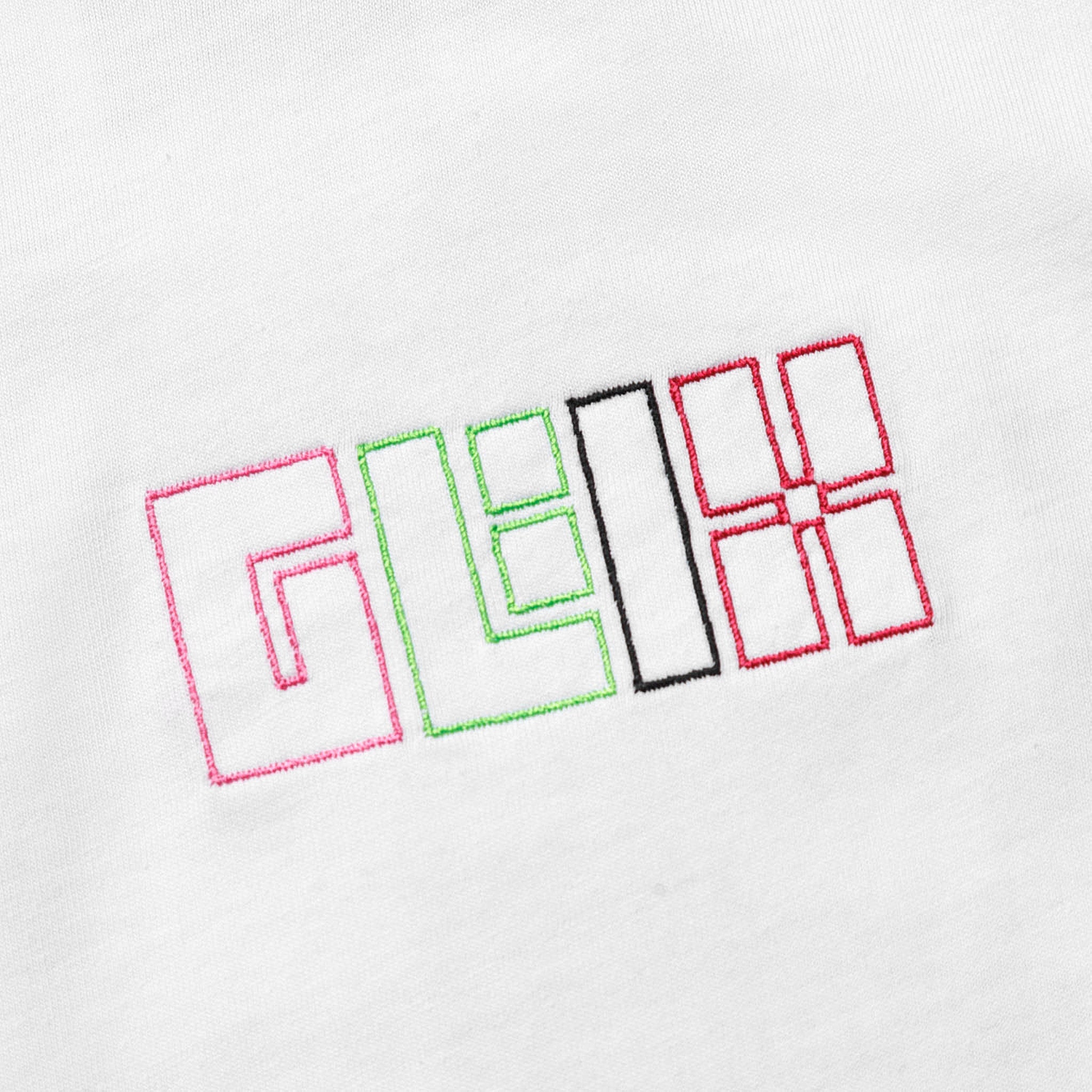 Close-up of the GLIX logo embroidered in pink, green, black, and red thread on the front of a white cotton crop top baby tee.