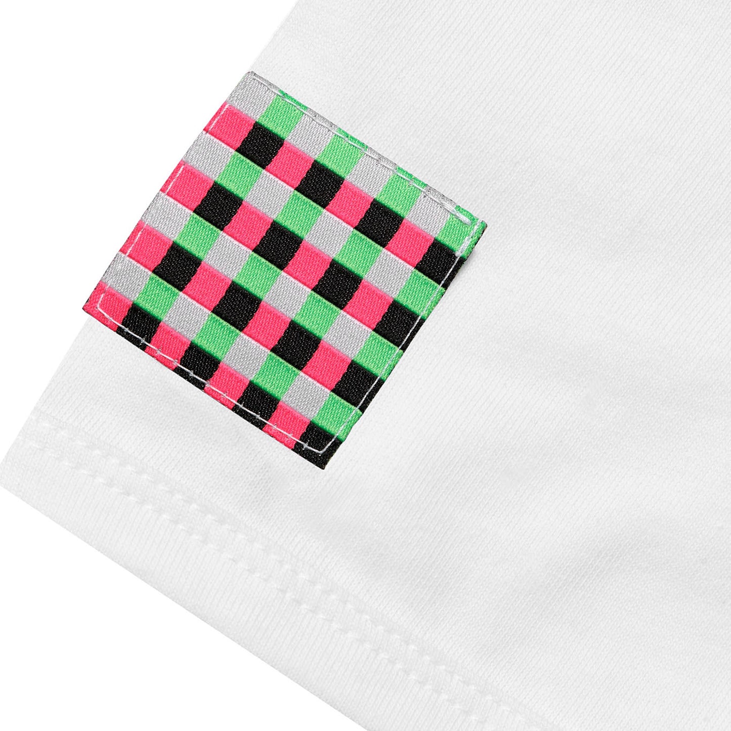 Close-up of a square woven checkered patch in pink, green, white, and black stitched onto the white fabric of the GLIX baby tee.
