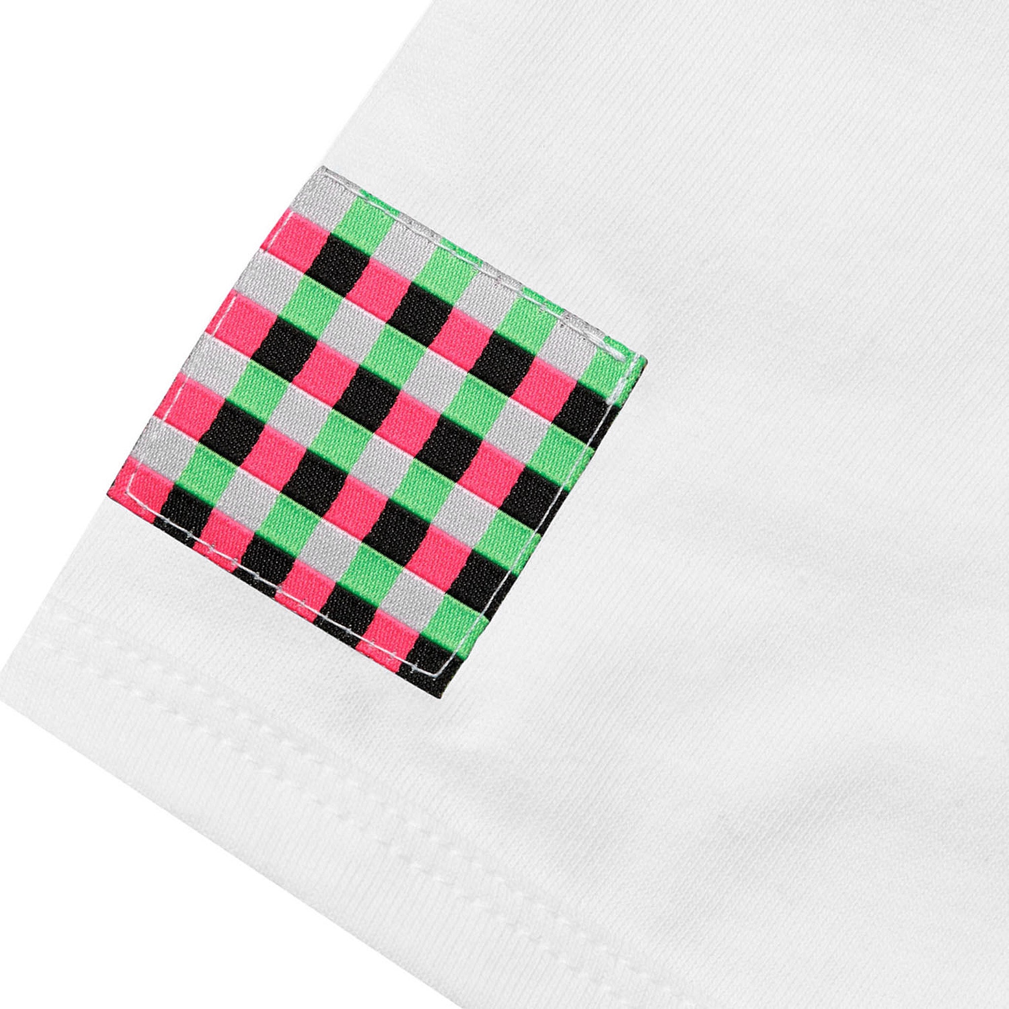 Detailed view of a square GLIX woven checkered patch in pink, green, and black stitched onto the hem of "The Rave" white baby tee.
