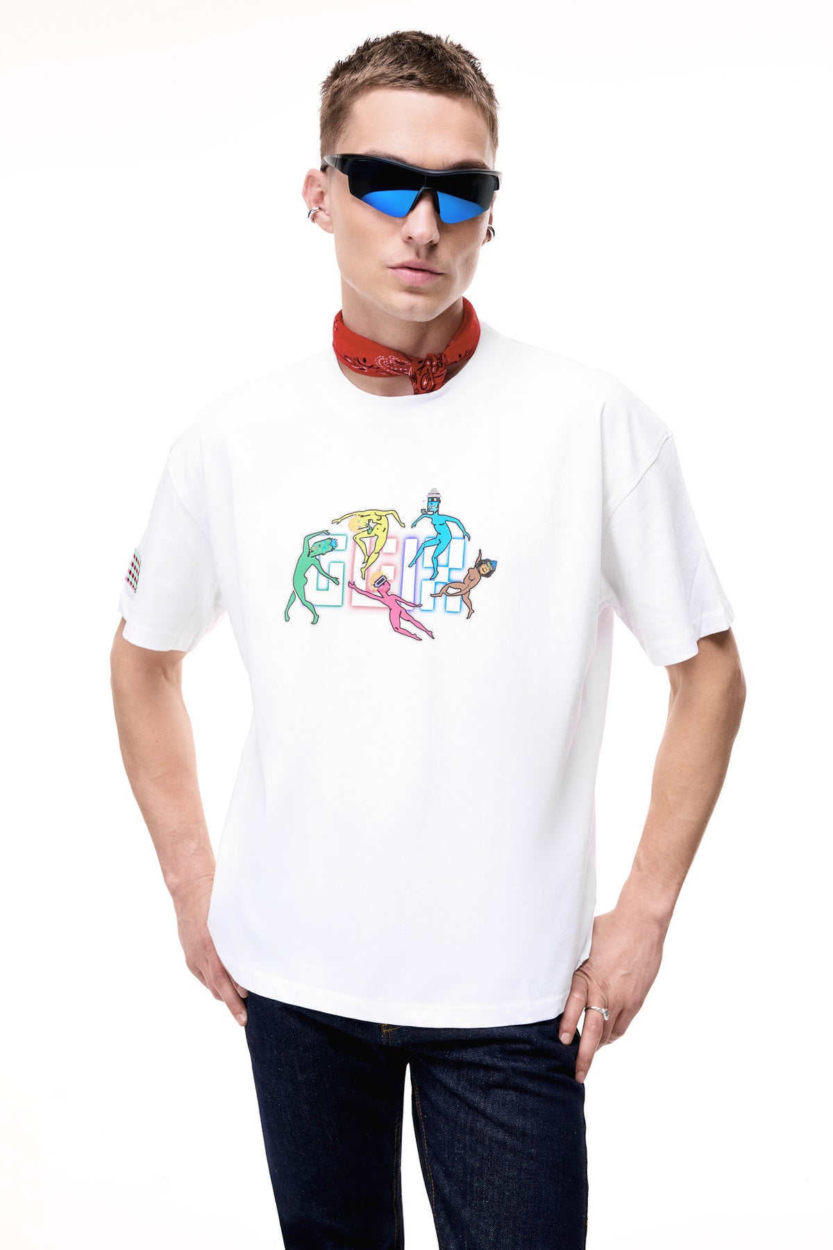 Front view of a male model wearing the white GLIX oversized t-shirt featuring a colorful graphic of dancing figures over the GLIX logo, styled with a red neck bandana and blue mirror sunglasses.