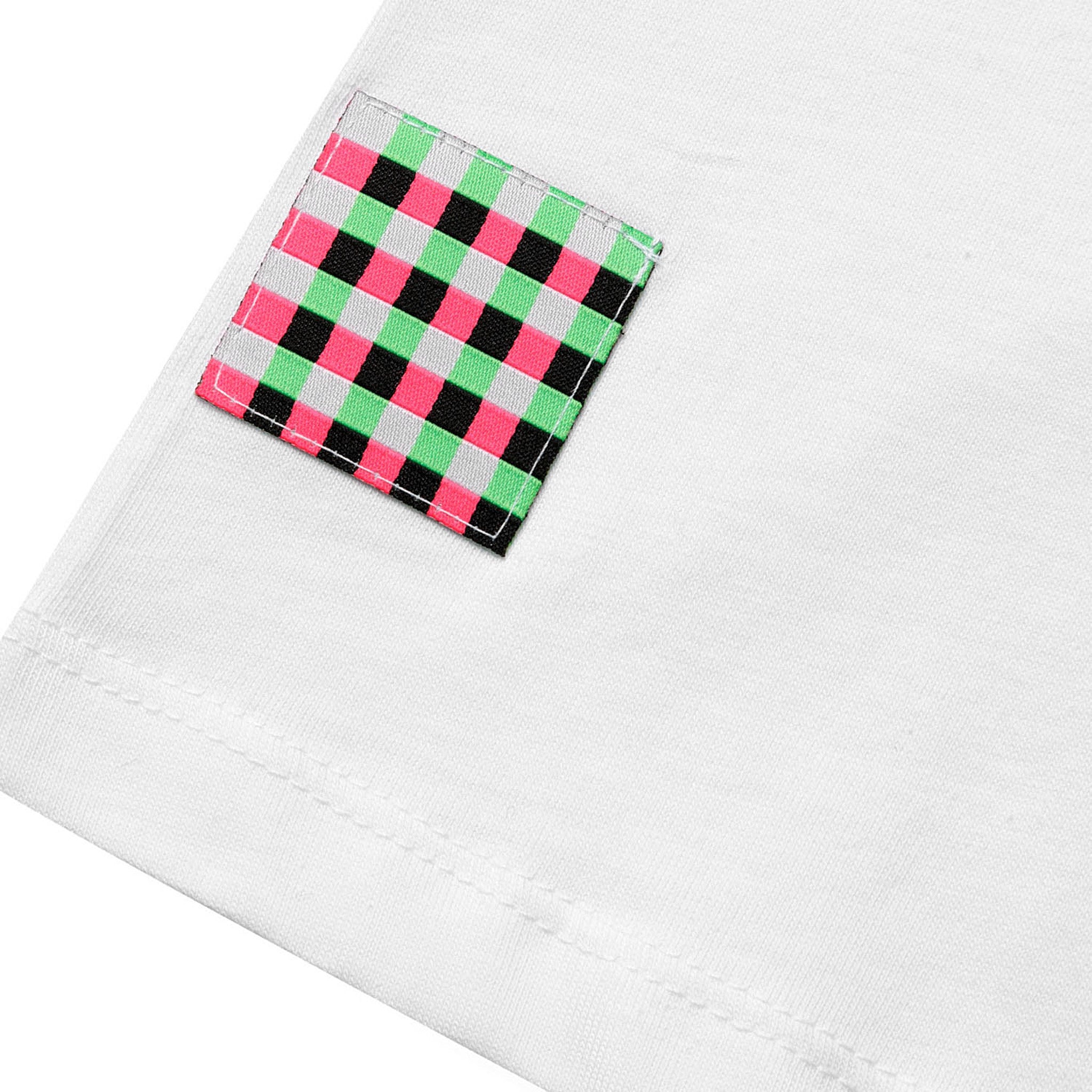 High-angle detail of GLIX logo,  a square checkered fabric patch in pink, green, and black stitched onto the white heavyweight cotton hem.